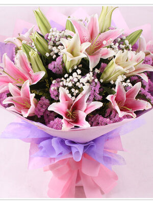 Pink lilies in a hand bouquet