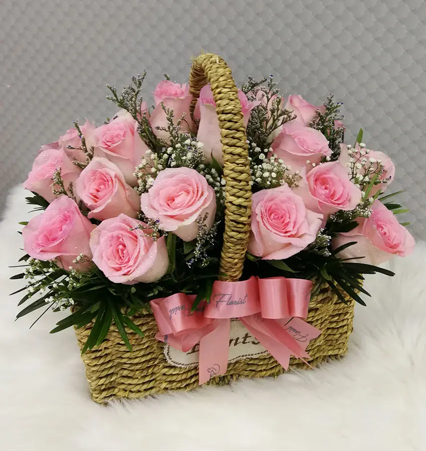 Pink roses arrange in a antique basket Blooming Florist