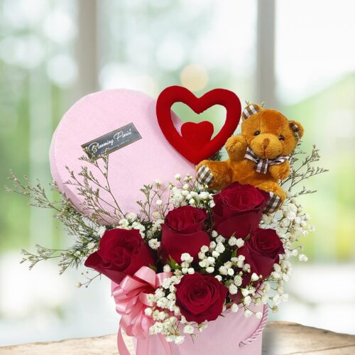 fresh red roses arranged in a box with a tiny bear and heart stick